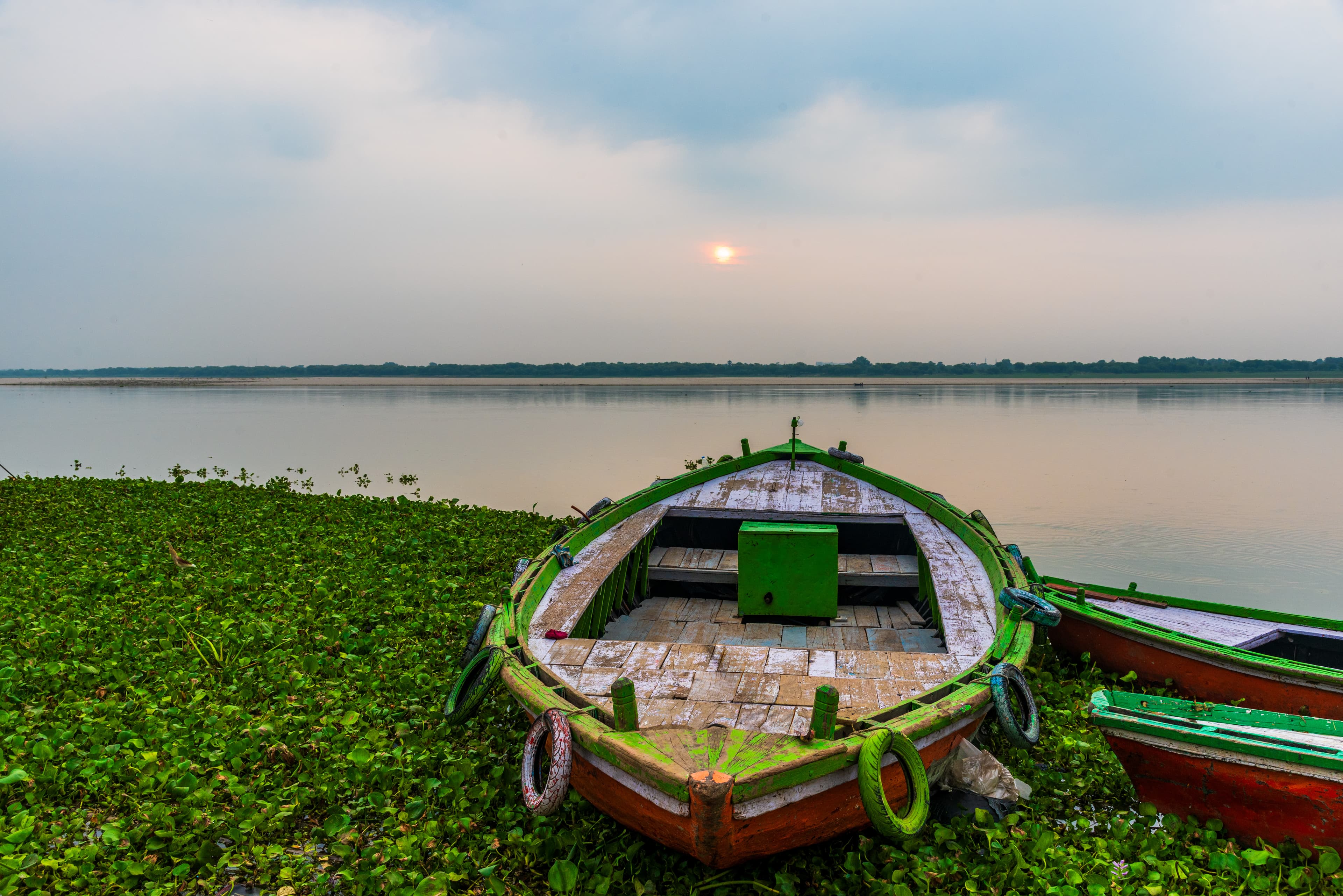 Sunset Stillness – Wooden Boat by Varanasi Riverbank